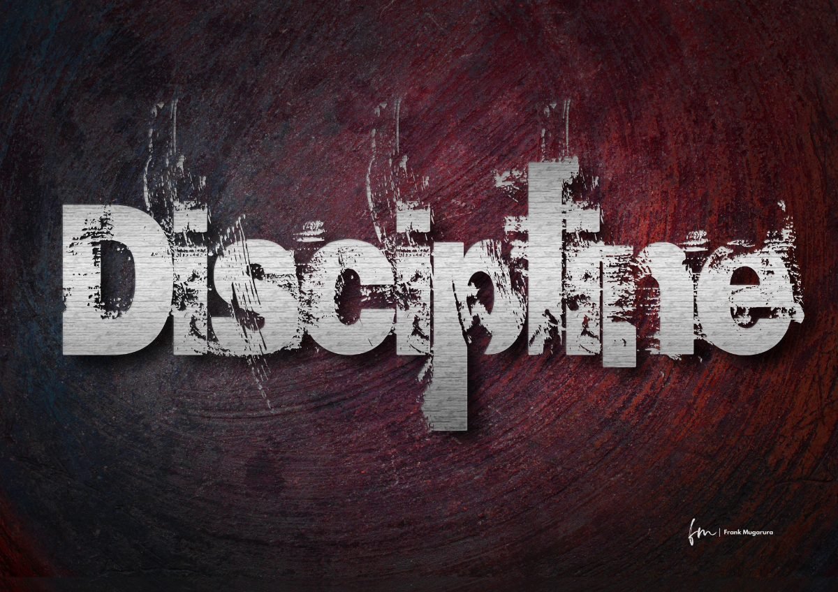 The word Discipline in worn metal type on a dark textured wall