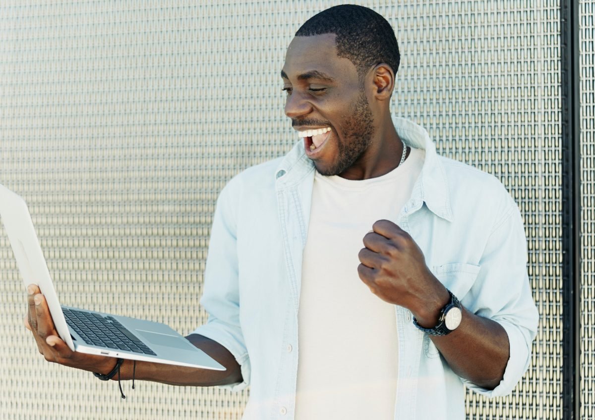 An entrepreneur celebrating a result on his laptop
